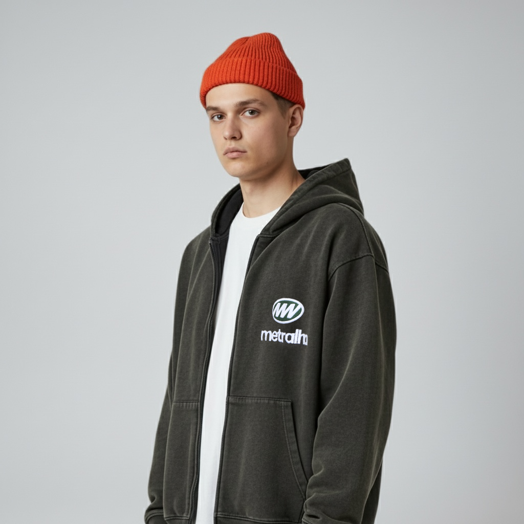 Person wearing a dark hoodie with a logo and a Red-orange beanie on a gray background