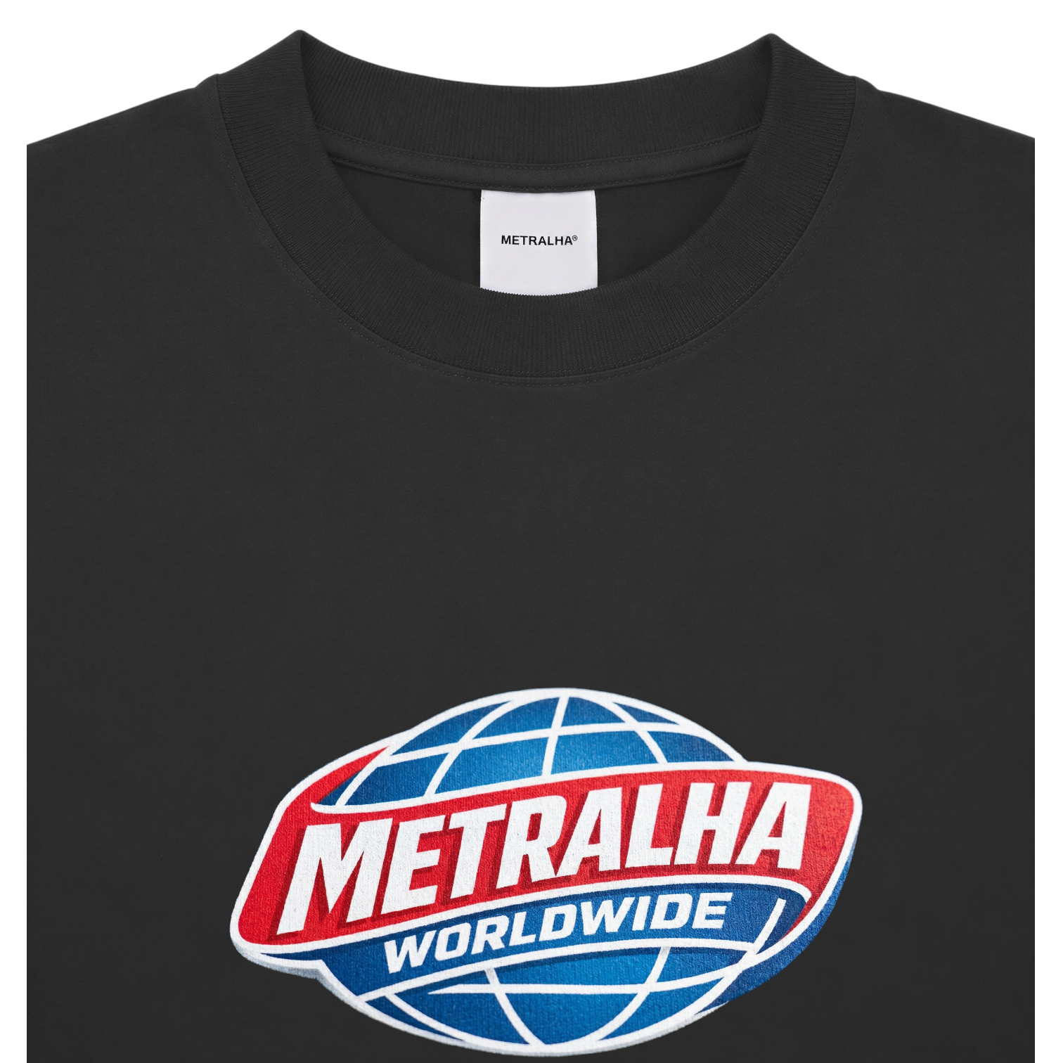 A close-up of a black crewneck t-shirt featuring a large 'METRALHA WORLDWIDE' logo printed on the chest. The logo depicts a blue globe with white grid lines, a red banner, and white text.